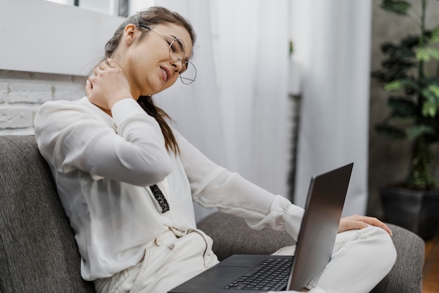 Photo gratuite femme ayant mal au cou alors qu'elle travaille à la maison