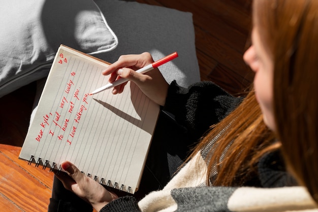 Photo gratuit une femme écrivant une lettre d'amour romantique à quelqu'un