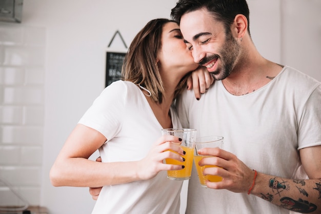 Femme embrassant l&#39;homme tout en appréciant le jus