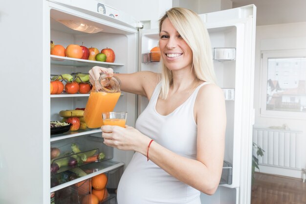 Femme enceinte avec du jus de frigo