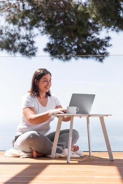 Femme à la maison à l'aide d'un ordinateur portable