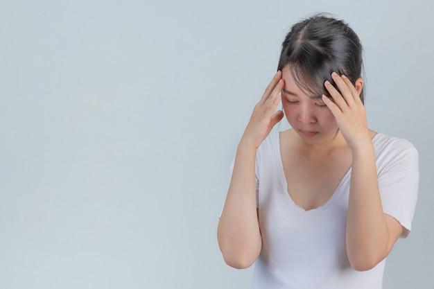 Femme montrant des signes de stress sur un mur gris