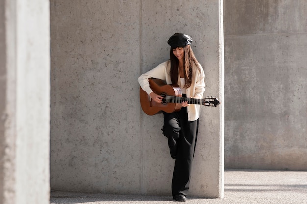 Photo gratuite femme pleine de coups jouant de la guitare