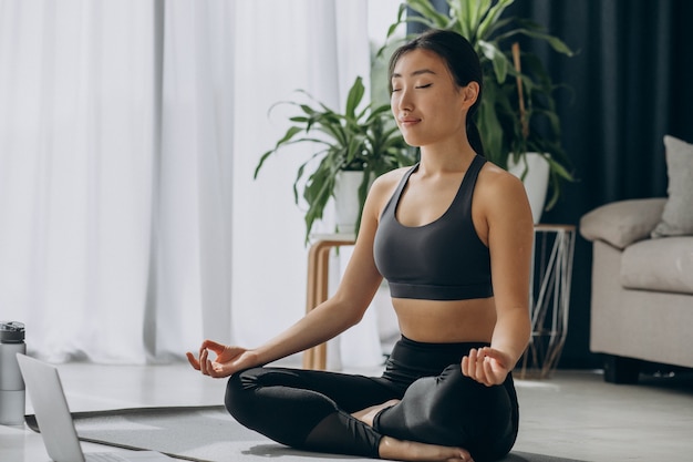 Photo gratuit femme pratiquant le yoga sur tapis à la maison