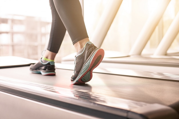 Photo gratuit femme qui court dans une salle de sport sur un concept de tapis roulant pour l'exercice, la forme physique et le mode de vie sain