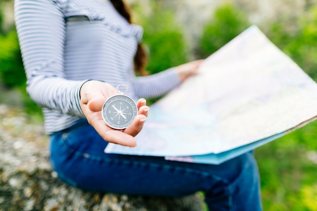 Photo gratuite femme regardant une carte assis sur un rocher