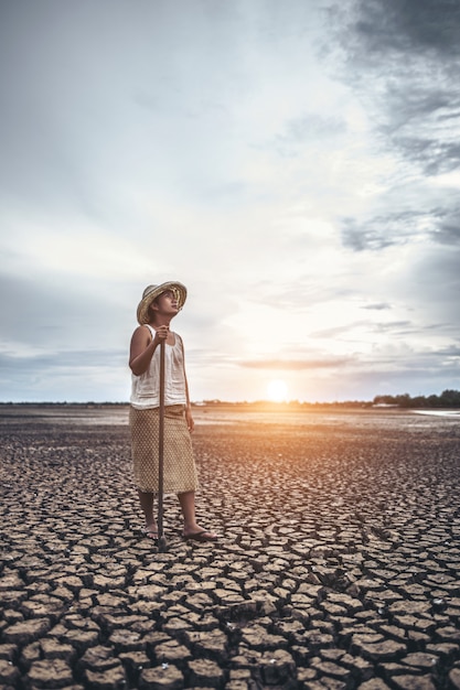 Photo gratuite la femme se leva et attrapa un siem sur un sol sec et regarda le ciel.