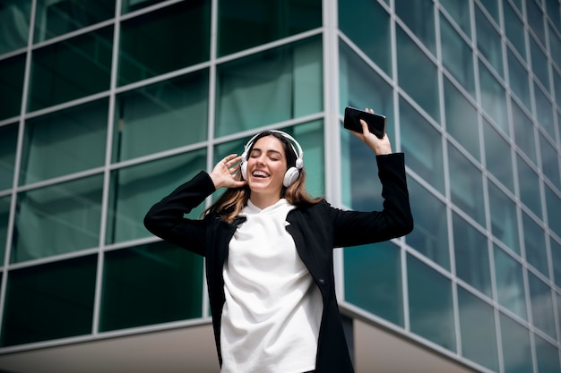 Photo gratuite femme souriante de coup moyen avec des écouteurs