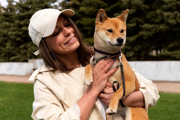 Photo gratuit femme souriante à coup moyen tenant un chien mignon