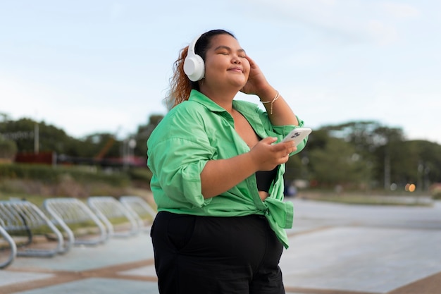 Femme de taille moyenne portant des écouteurs