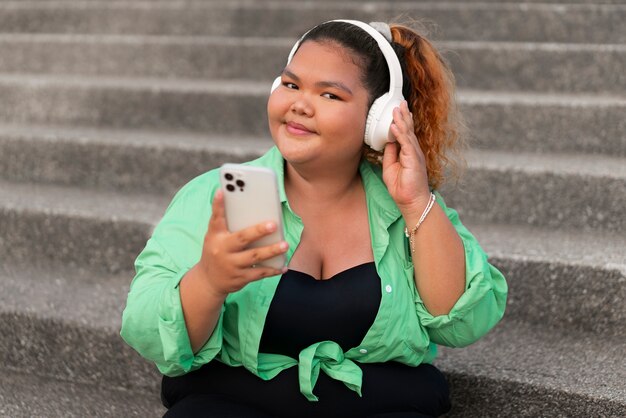 Femme de taille moyenne portant des écouteurs