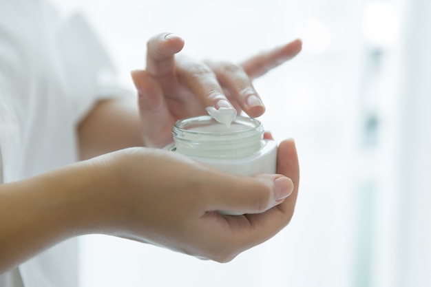 Photo gratuite femme tient un pot avec une crème cosmétique dans ses mains