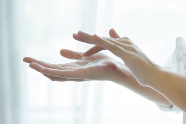 Photo gratuite femme tient un pot avec une crème cosmétique dans ses mains