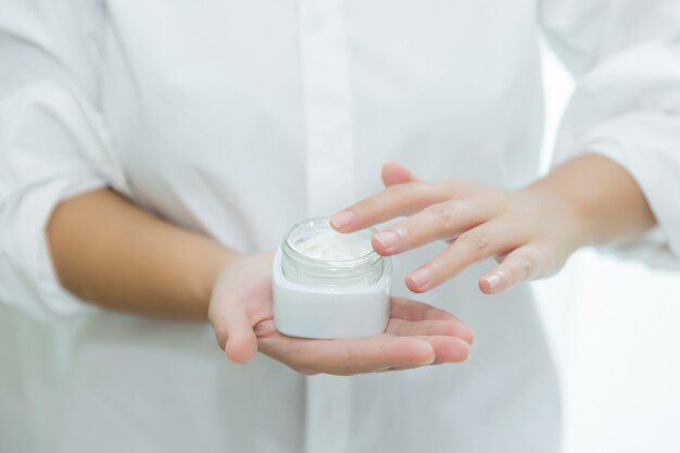 Photo gratuit femme tient un pot avec une crème cosmétique dans ses mains