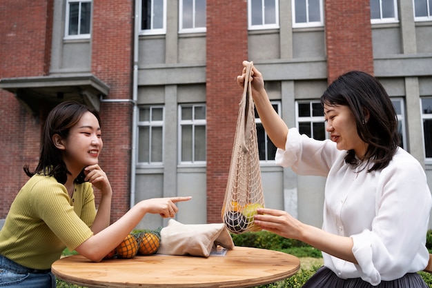 Photo gratuite femmes à coup moyen avec des sacs en tissu