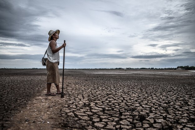 Femmes debout sur un sol sec et des engins de pêche, réchauffement de la planète et crise de l'eau