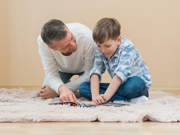 Photo gratuite fête des pères papa et fils lisant une bande dessinée