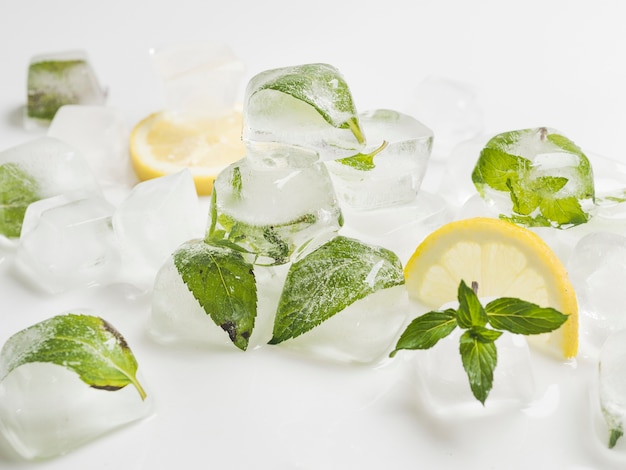 Photo gratuite feuilles en cubes de glace avec citrons