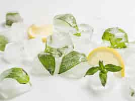 Photo gratuite feuilles en cubes de glace avec citrons