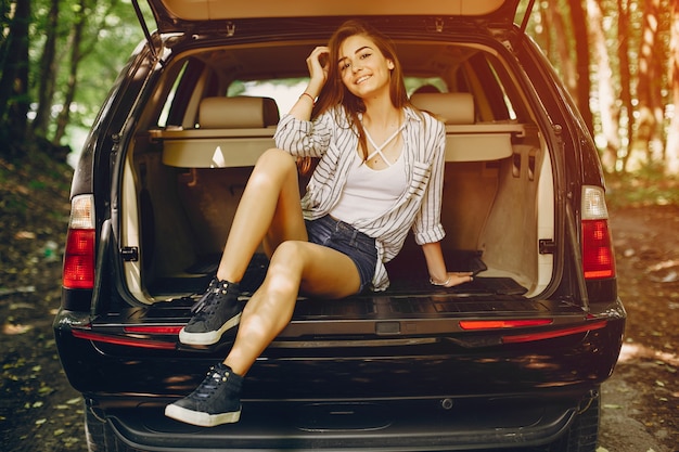 Photo gratuit fille dans un parc d&#39;été près de la voiture