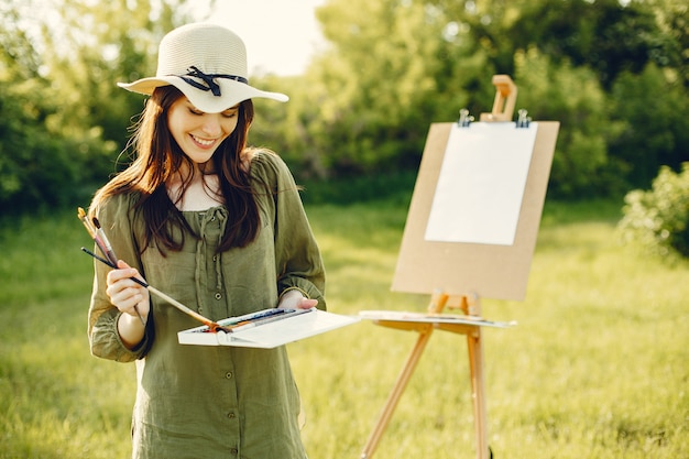 Photo gratuit fille élégante et belle peinture dans un champ