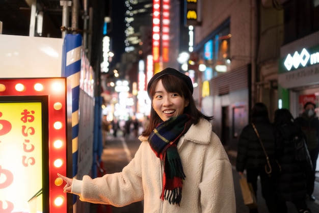 Photo gratuite fille souriante à coup moyen pointant vers le signe