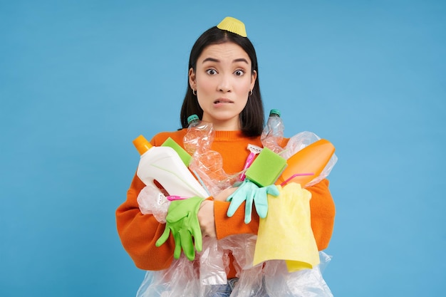 Photo gratuite fille avec des tas d'ordures entourées de litière semble concernée trie les déchets et recycle la zone bleue