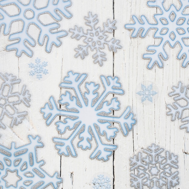 Photo gratuite flocons de neige sur un fond en bois blanc