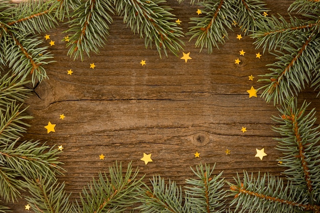 Fond en bois avec des feuilles de pin et des étoiles