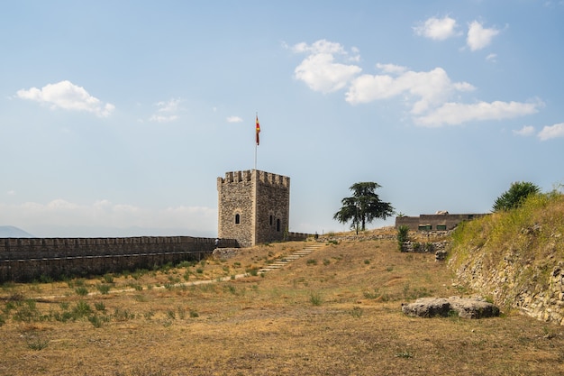 Photo gratuite la forteresse de skopje entourée d'herbe et d'arbres sous la lumière du soleil en macédoine du nord