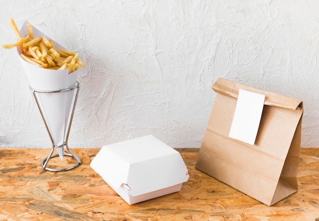 Photo gratuite frites et colis de nourriture mock up sur le dessus de table en bois