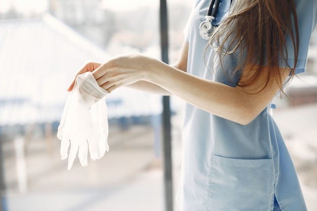 Photo gratuite gants blancs. doctoresse. femme par fenêtre