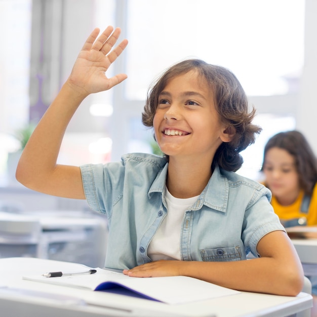 Photo gratuite garçon souriant avec main levée