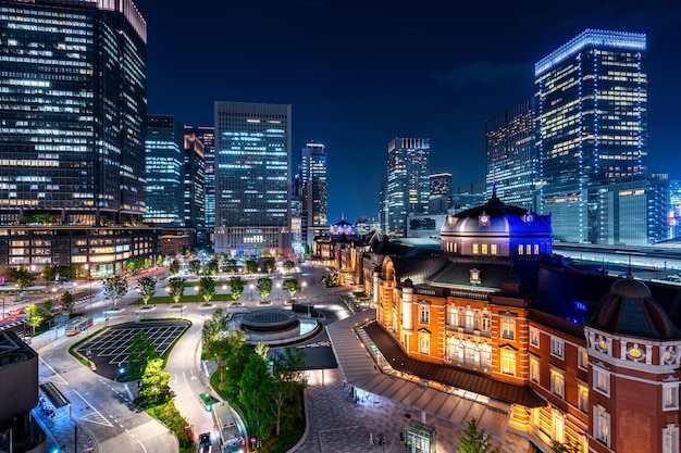 Photo gratuite la gare de tokyo et le bâtiment du quartier des affaires la nuit, au japon.