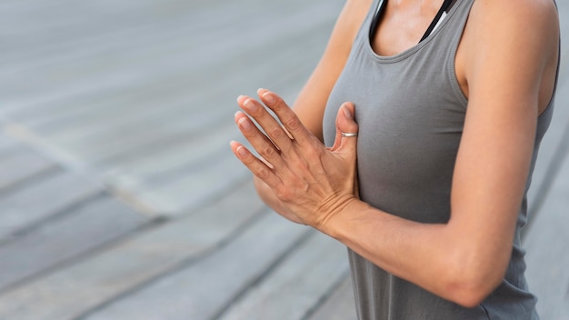 Photo gratuite gros plan femme pratiquant le yoga avec les mains jointes