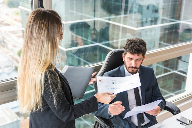 Gros plan, femme, secrétaire, rapport financier, à, directeur, homme, lieu de travail