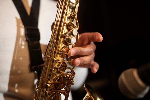 Photo gratuite gros plan sur la main jouant du saxophone