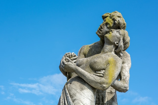 Photo gratuite un gros plan d'une pierre a fait une statue d'un couple avec un ciel bleu