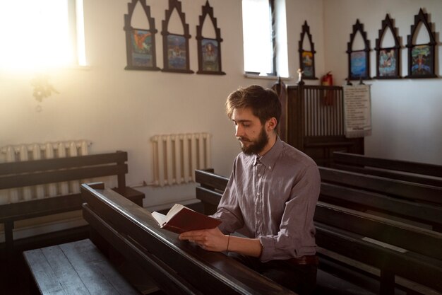 Gros plan sur le prêtre lisant la bible