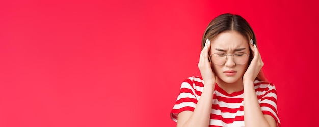 Photo gratuite gros plan sous pression en détresse jeune femme asiatique saisir la tête toucher les tempes en fronçant les yeux fermer la tête pliée