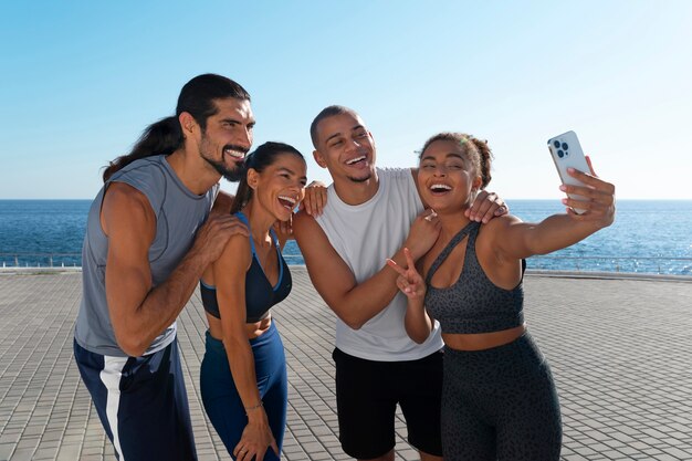 Groupe de personnes prenant un selfie en faisant de l'exercice ensemble à l'extérieur