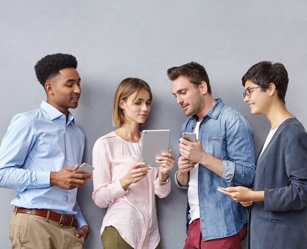 Groupe de personnes avec smartphones et tablettes