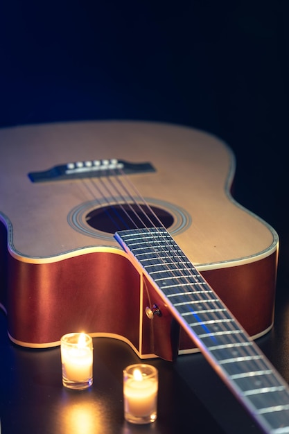 Photo gratuite guitare acoustique sur un fond noir avec des bougies