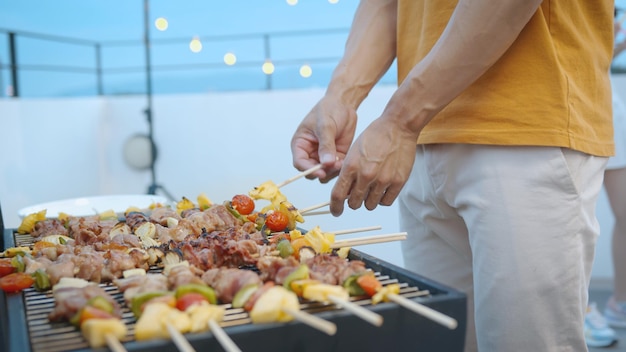 Photo gratuit heureux homme asiatique avec des amis lors d'un dîner barbecue et savourant un repas ensemble