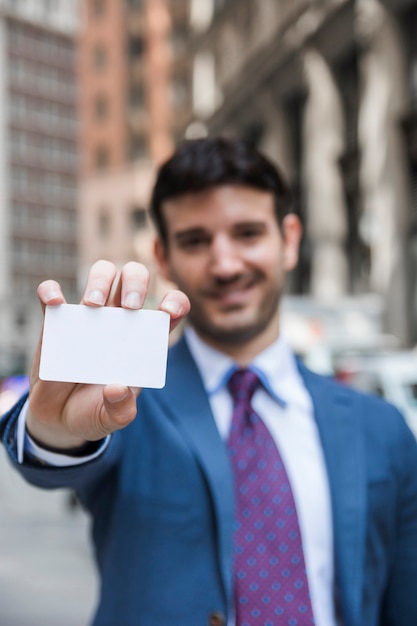 Photo gratuite homme d'affaires flou démontrant la carte de visite