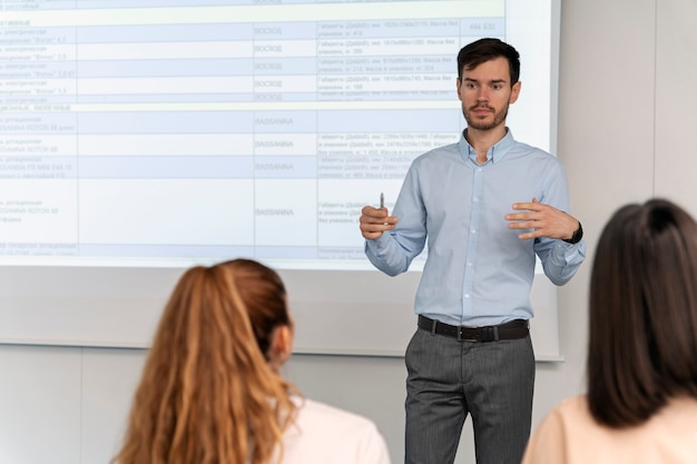 Photo gratuite homme d'affaires tenant une présentation au bureau pour ses collègues