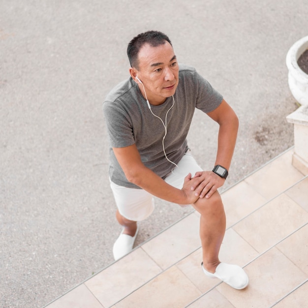 Photo gratuite homme à angle élevé exerçant avec des écouteurs