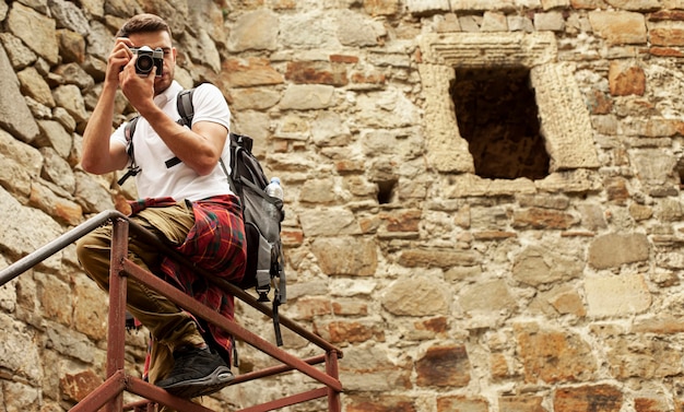 Photo gratuite homme avec appareil photo sur les escaliers du château à prendre des photos