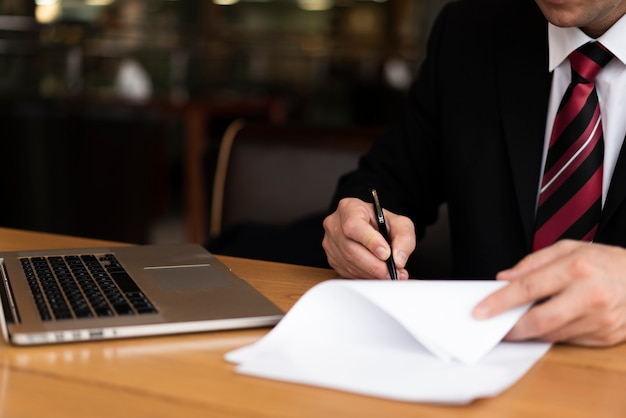 Photo gratuit homme au bureau écrit sur papier