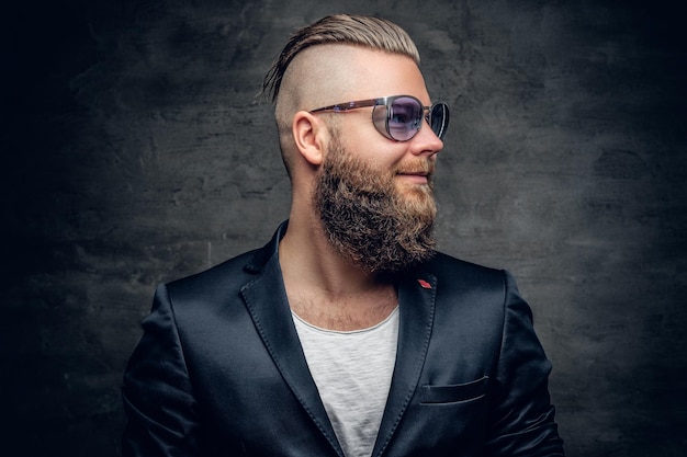 Photo gratuite homme barbu à la mode en riant avec des lunettes de soleil, vêtu d'une veste violette.